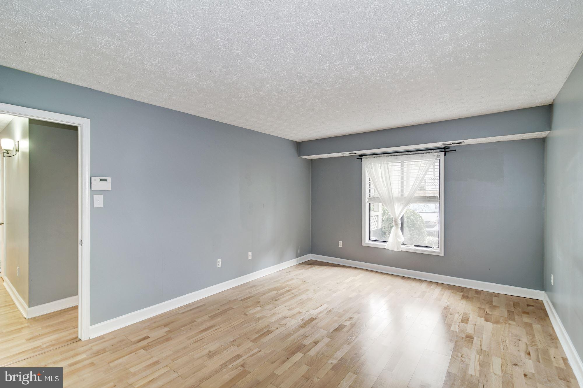 2224 Hunter's Run Drive, Unit 2224 Reston, VA 20191 - Photo 13 of 21 an empty room with wooden floor and windows