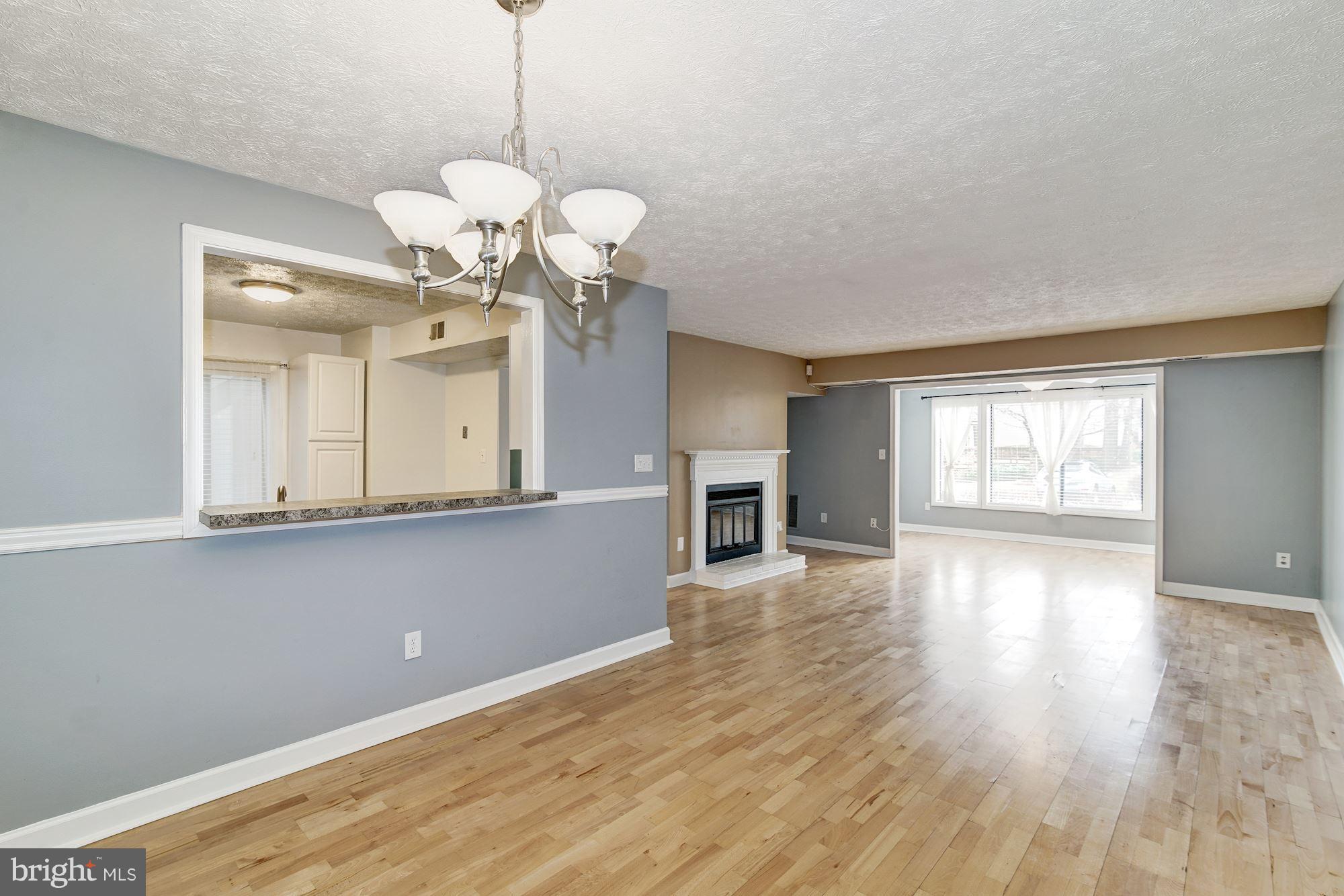 2224 Hunter's Run Drive, Unit 2224 Reston, VA 20191 - Photo 5 of 21 a view of a room with wooden floor and chandelier