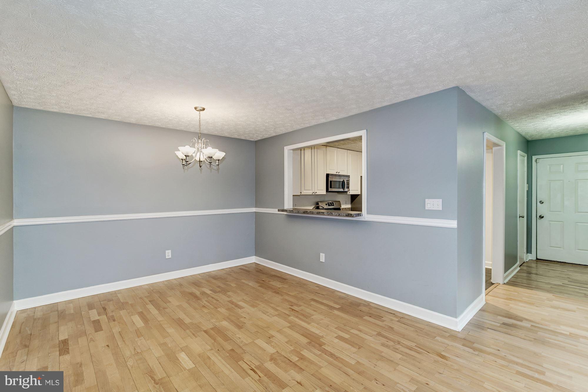 2224 Hunter's Run Drive, Unit 2224 Reston, VA 20191 - Photo 6 of 21 a view of a room with wooden floor and a ceiling fan
