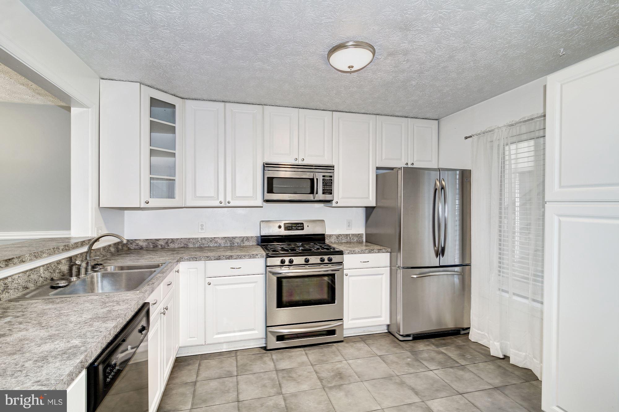 2224 Hunter's Run Drive, Unit 2224 Reston, VA 20191 - Photo 10 of 21 a kitchen with a stove a sink and a refrigerator