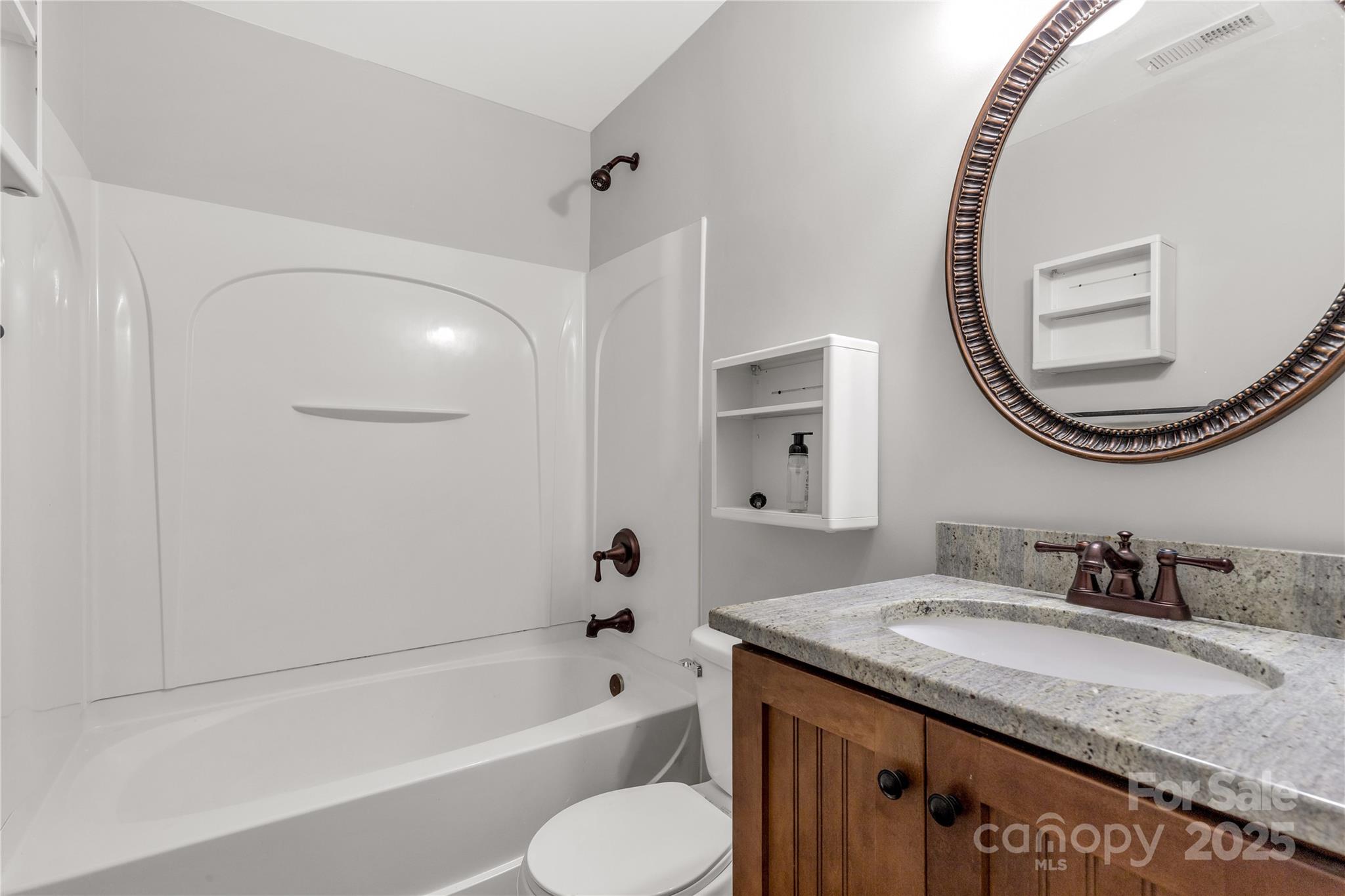 4923 Park Road, Unit E Charlotte, NC 28209 - Photo 11 of 24 a bathroom with a granite countertop sink mirror toilet and bathtub