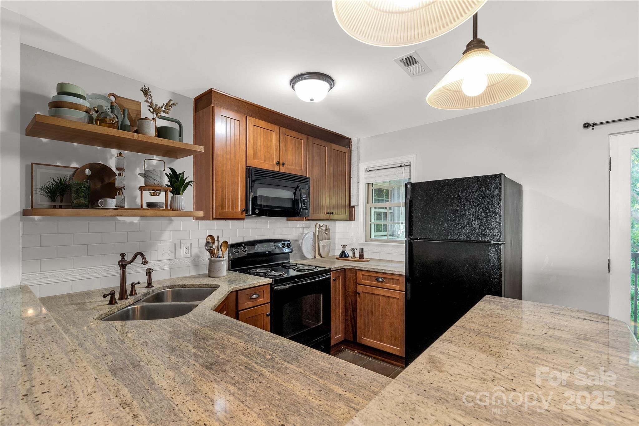 4923 Park Road, Unit E Charlotte, NC 28209 - Photo 7 of 24 a kitchen with stainless steel appliances granite countertop a sink refrigerator and microwave