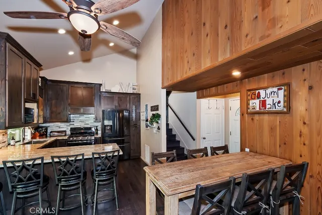 a kitchen with a table chairs and flat screen tv