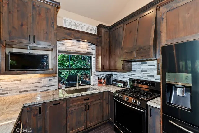 a kitchen with stainless steel appliances a stove a sink and a microwave