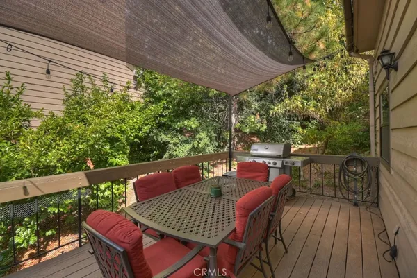 a patio with wooden floor a yard a table and chairs