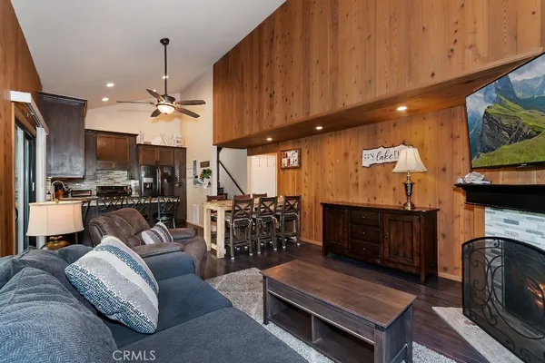 a living room with furniture a fireplace and kitchen view