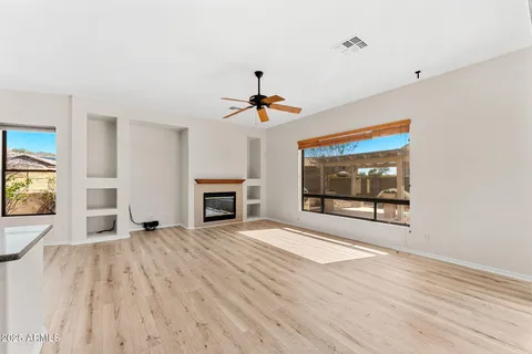 a view of a room with wooden floor and ceiling fan