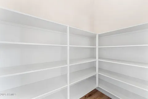 a view of a room with wooden floor and a ceiling fan