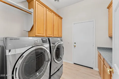 a large kitchen with kitchen island a large counter top stainless steel appliances and cabinets