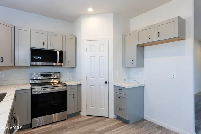 a kitchen with cabinets appliances and a wooden floor