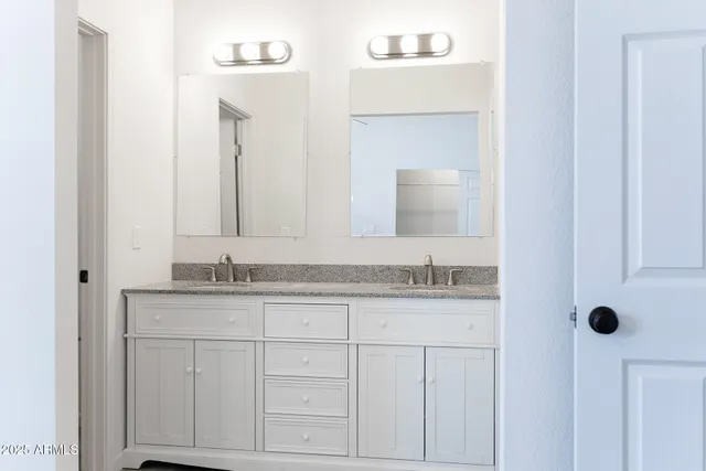 a bathroom with a granite countertop sink vanity and mirror