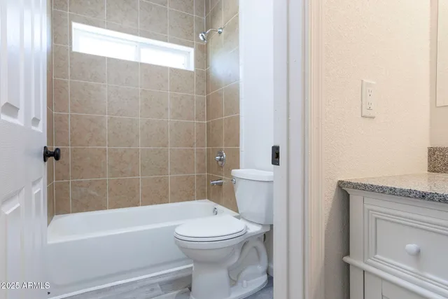 a bathroom with a granite countertop toilet a sink and bathtub