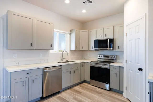 a kitchen with white cabinets stainless steel appliances and sink