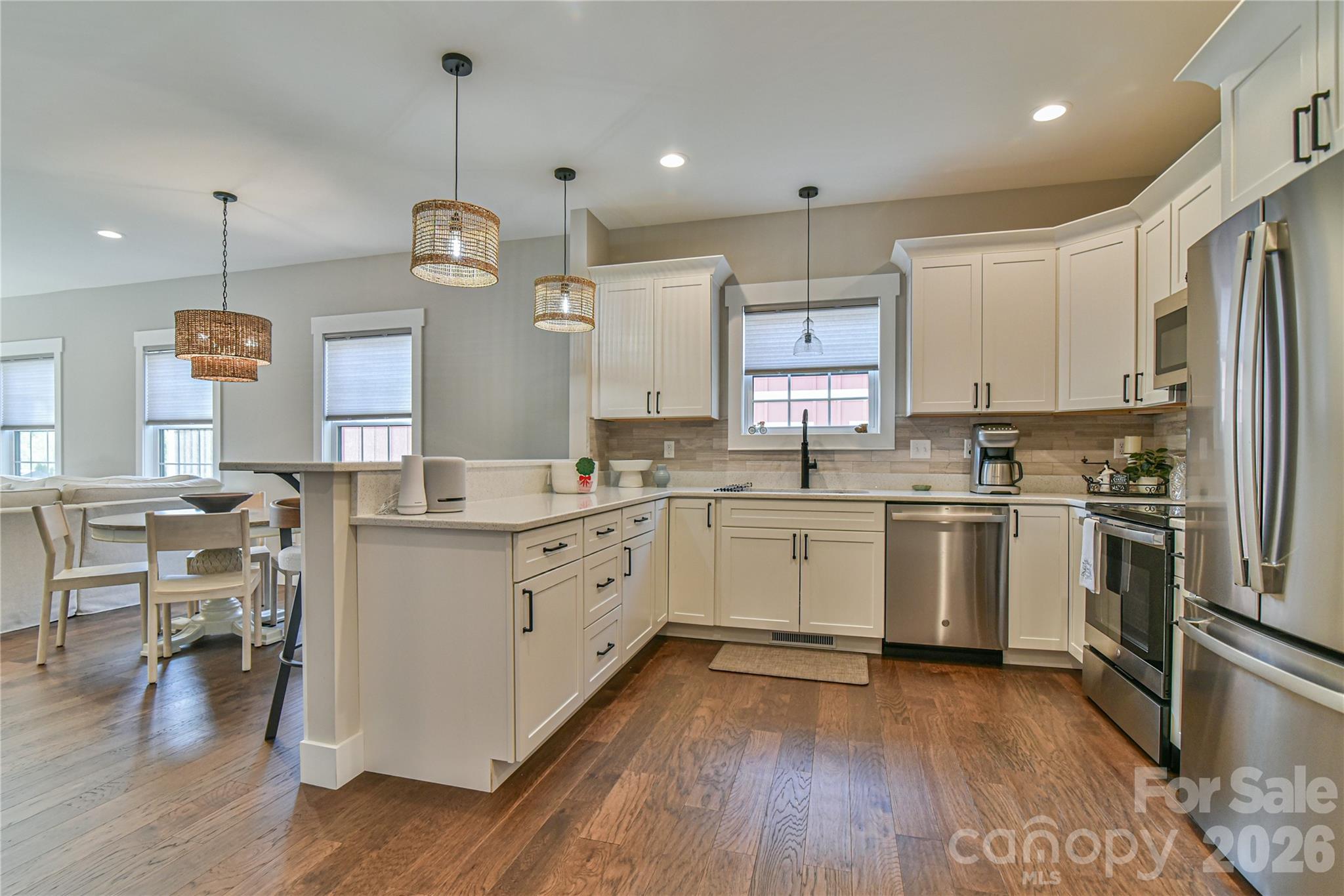310 Portmanvilla Road Black Mountain, NC 28711 - Photo 2 of 30 a kitchen with granite countertop a refrigerator a sink dishwasher a stove and white cabinets with wooden floor