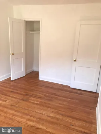 an empty room with wooden floor and cabinet