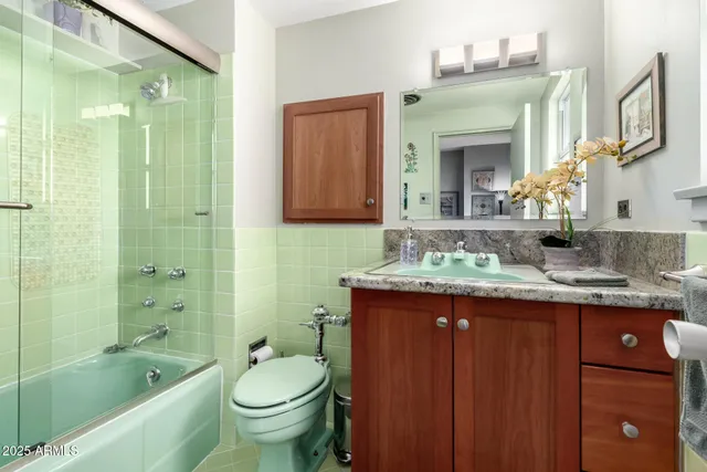 a bathroom with a granite countertop toilet a sink and a bathtub