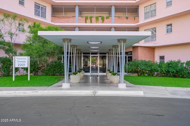 a view of yellow house with a yard and plants