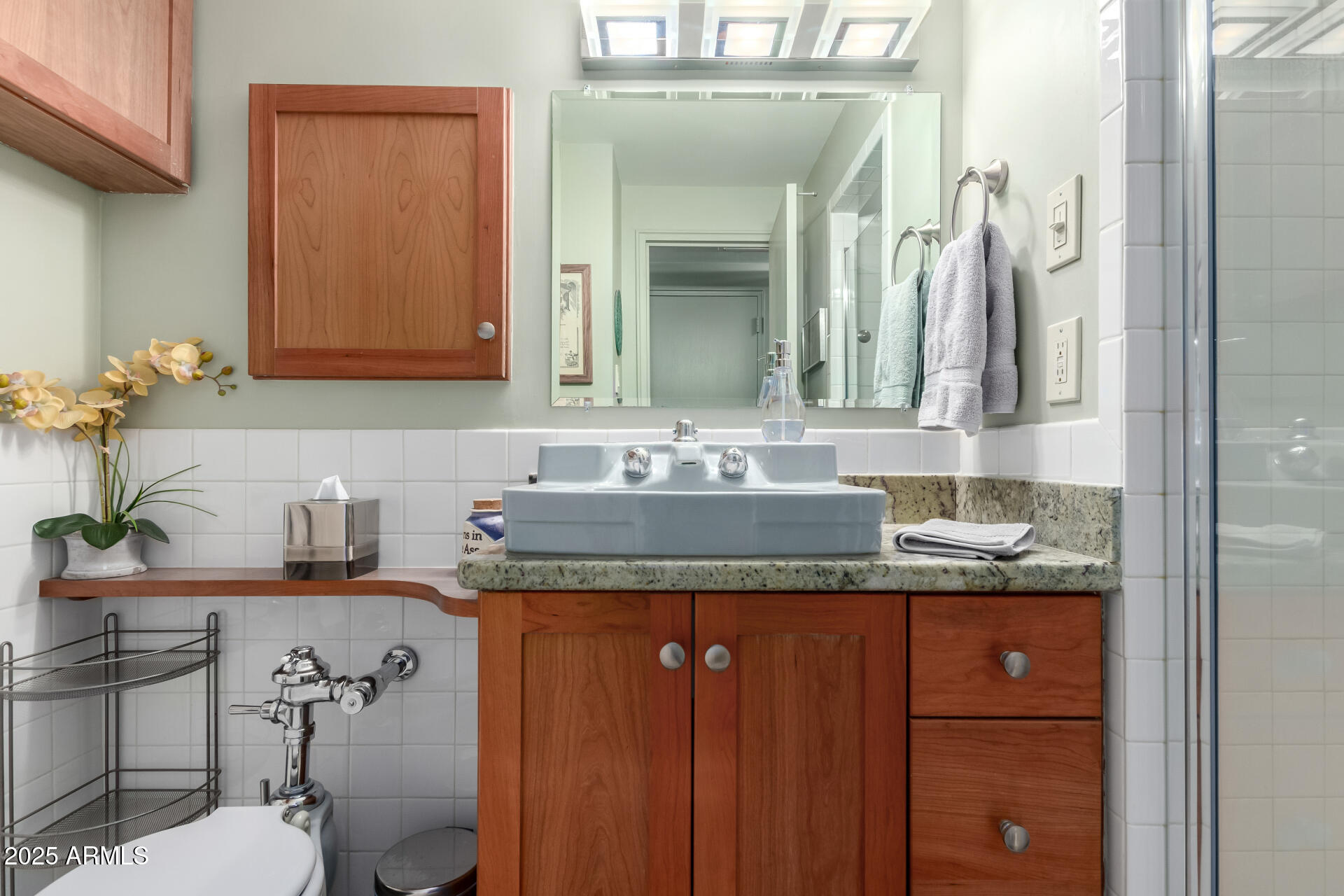 2201 North Central Avenue, Unit 5B Phoenix, AZ 85004 - Photo 21 of 35 a bathroom with a granite countertop sink a toilet and mirror