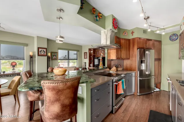 a kitchen with stainless steel appliances granite countertop a sink a stove and refrigerator