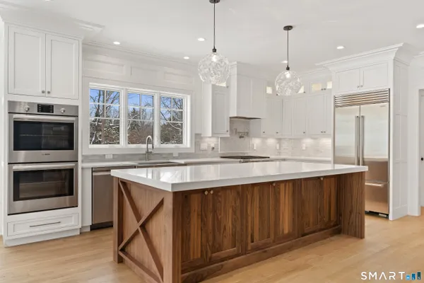 a kitchen with kitchen island granite countertop a stove and a sink