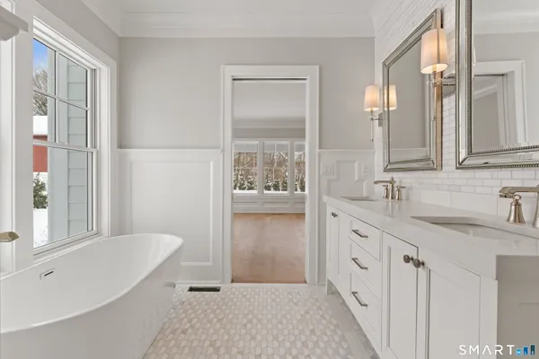 a bathroom with a granite countertop tub sink and mirror