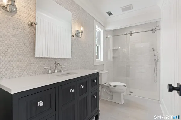 a bathroom with a double vanity sink toilet and a mirror
