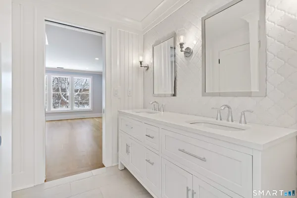 a bathroom with a double vanity sink and a mirror