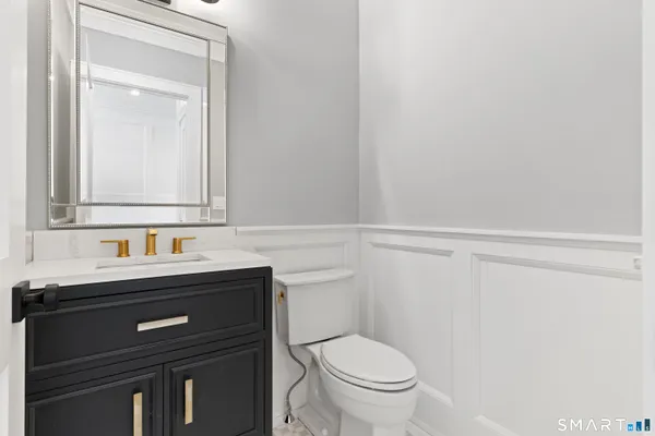 a bathroom with a sink a toilet and a mirror