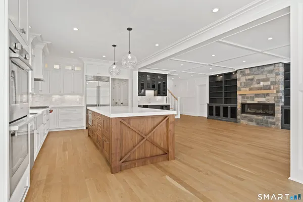 a large kitchen with stainless steel appliances kitchen island a large counter top and a stove top oven