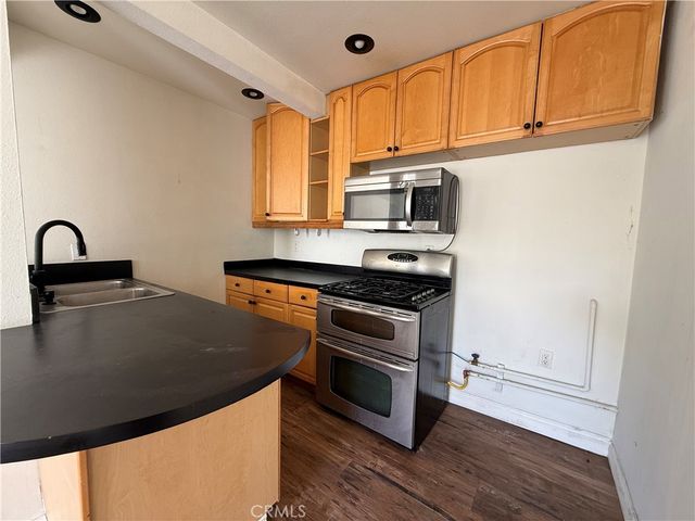 a kitchen with stainless steel appliances granite countertop a stove a sink and a microwave