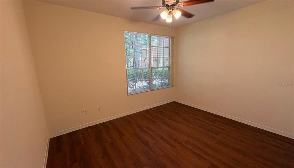 6348 Raleigh Street, Unit 1304 Orlando, FL 32835 - Photo 17 of 20 an empty room with wooden floor chandelier fan and windows