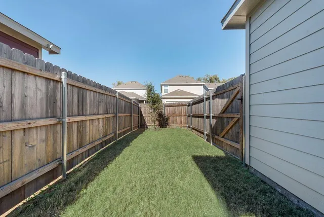 a view of a backyard with wooden fence