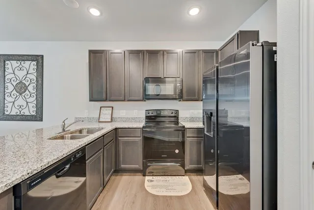 a bathroom with a granite countertop sink a toilet a mirror and shower