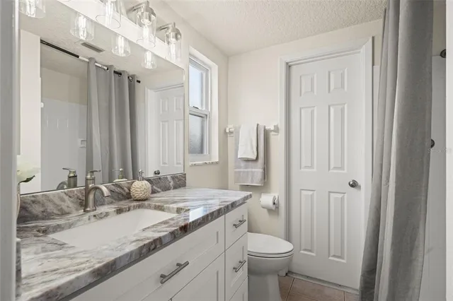 a bedroom with a large bed and a potted plant