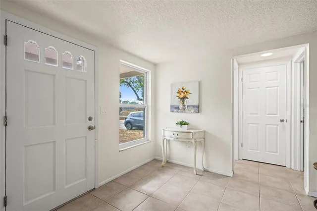 a kitchen with stainless steel appliances granite countertop a stove a sink a microwave a refrigerator and white cabinets