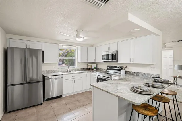 a kitchen with granite countertop a sink a stove and microwave
