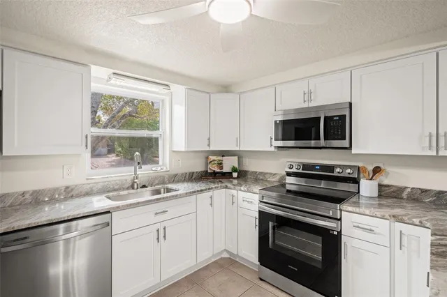 a bathroom with a granite countertop sink a mirror and shower