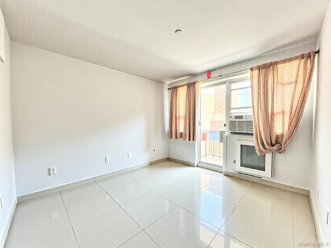 42-38 Judge Street, Unit 3A Queens, NY 11373 - Photo 8 of 9 Spare room with light tile patterned floors and cooling unit