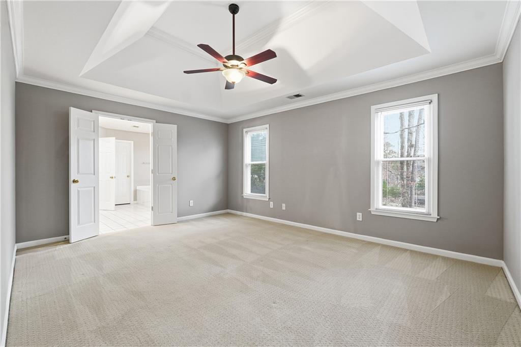 5145 Harbour Ridge Drive Alpharetta, GA 30005 - Photo 11 of 25 an empty room with chandelier fan and windows