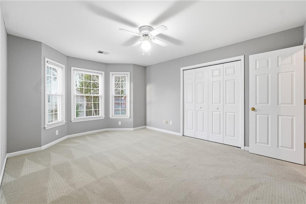 5145 Harbour Ridge Drive Alpharetta, GA 30005 - Photo 15 of 25 an empty room with windows and chandelier fan