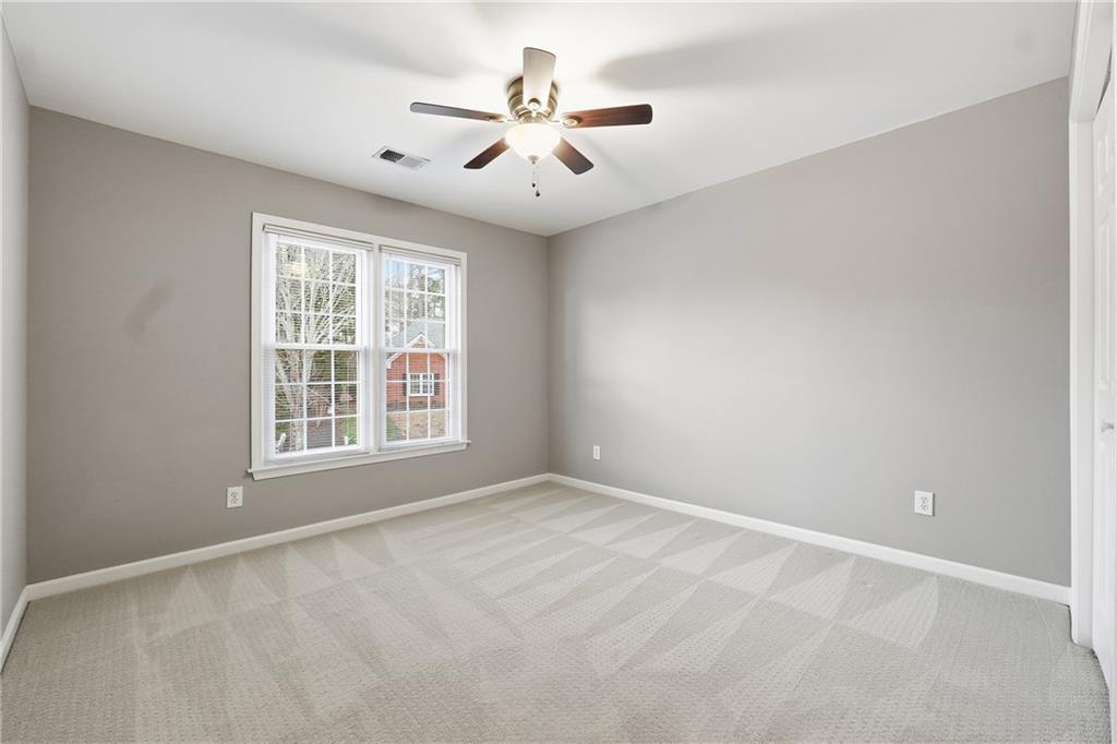 5145 Harbour Ridge Drive Alpharetta, GA 30005 - Photo 18 of 25 an empty room with windows and ceiling fan