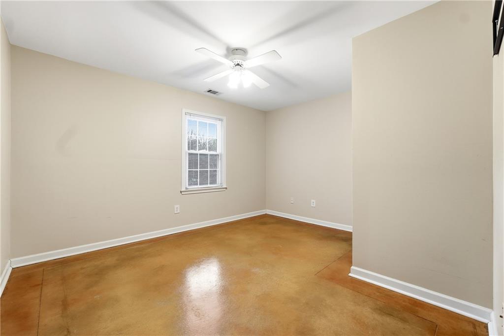 5145 Harbour Ridge Drive Alpharetta, GA 30005 - Photo 24 of 25 an empty room with a chandelier fan and windows