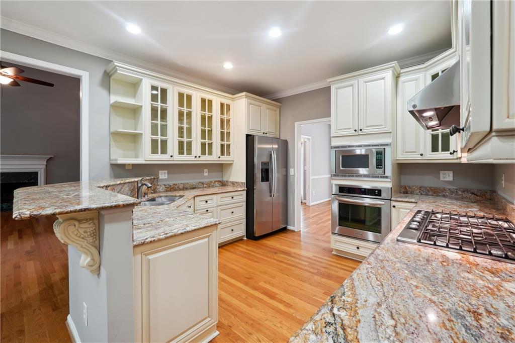 5145 Harbour Ridge Drive Alpharetta, GA 30005 - Photo 8 of 27 a kitchen with kitchen island granite countertop a stove a sink a refrigerator and cabinets