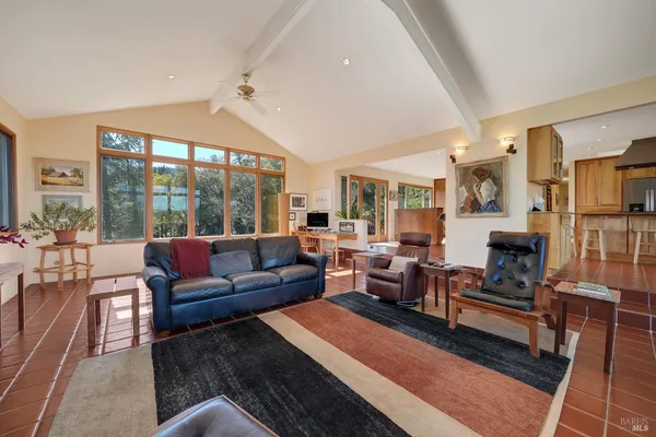 a living room with furniture large windows a fireplace and a rug