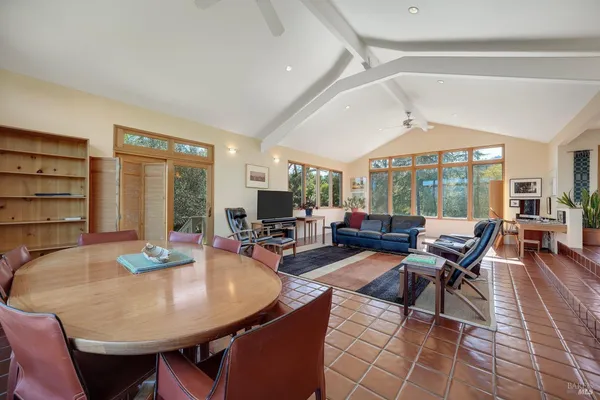 a living room with furniture a large window and wooden floor