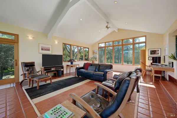 a living room with furniture a flat screen tv and a large window