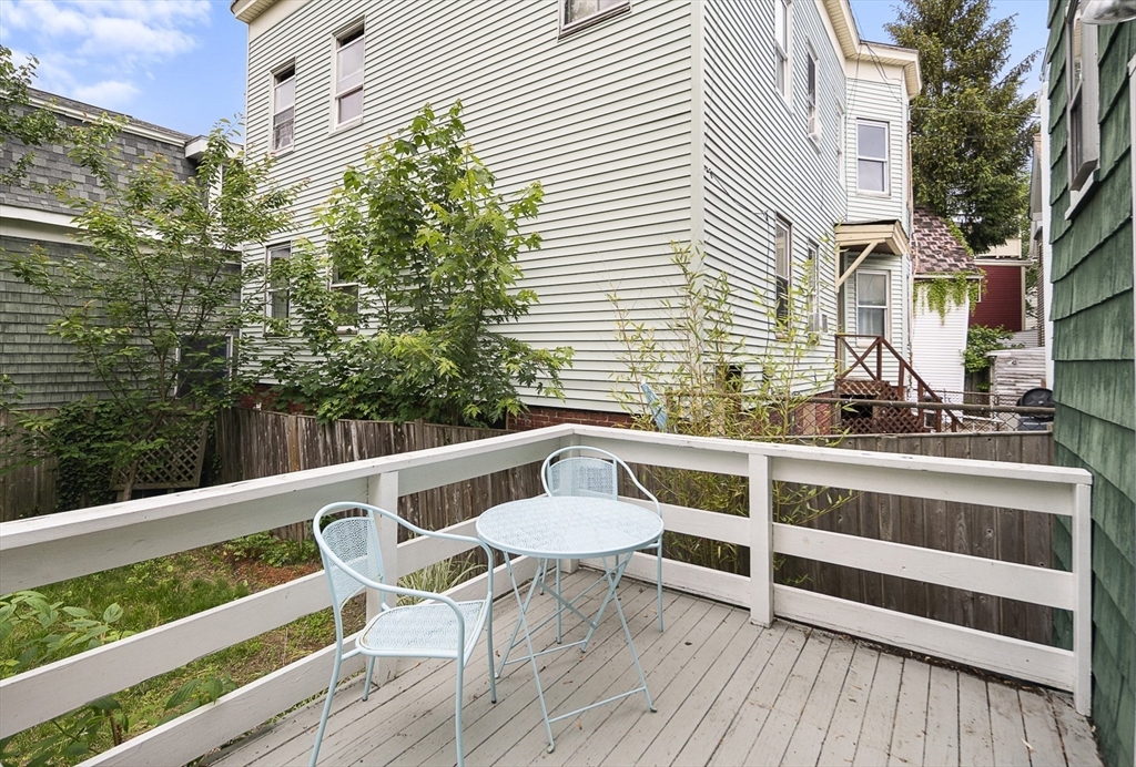 28 Summer Street, Unit 1 Somerville, MA 02143 - Photo 12 of 14 a balcony with table and chairs and wooden floor