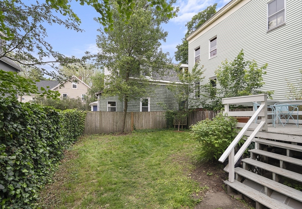 28 Summer Street, Unit 1 Somerville, MA 02143 - Photo 13 of 14 a view of a backyard with plants and a bench
