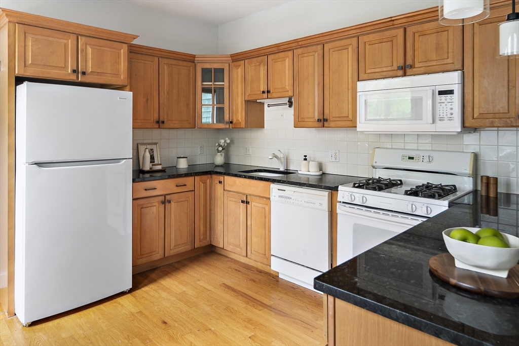 28 Summer Street, Unit 1 Somerville, MA 02143 - Photo 6 of 14 a kitchen with stainless steel appliances granite countertop a sink stove and refrigerator