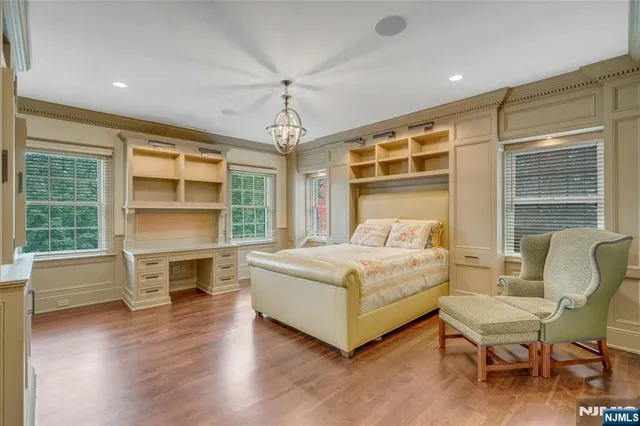 a white bed sitting in a room next to a window